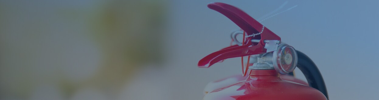 Close-up of the top of a fire extinguisher, overlaid with a blue gradient