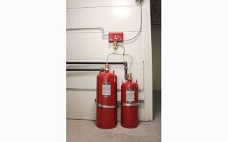 Two fire extinguishers placed near a wall in a facility